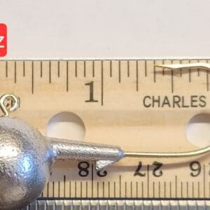 A metal ball is sitting on top of a ruler.