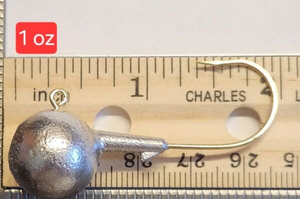 A metal ball is sitting on top of a ruler.