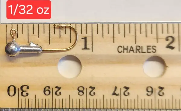 A wooden ruler with a fishing hook and a measuring tape.