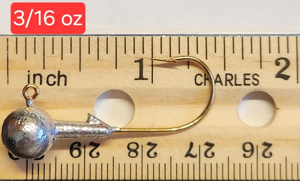 A fishing hook is measured on the ruler.