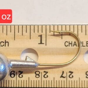 A fishing hook is shown on top of a ruler.