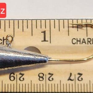 A fishing hook is measured on the ruler.