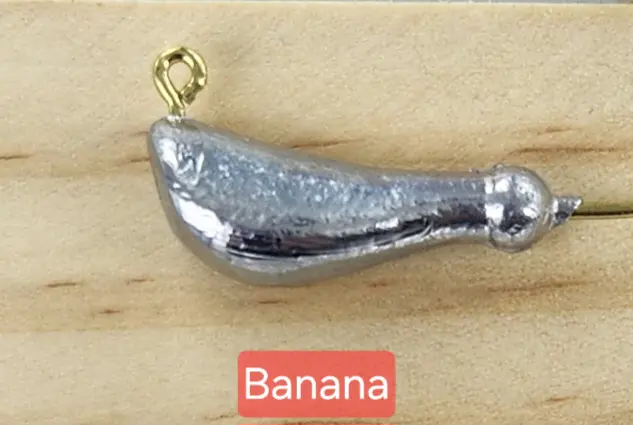 A banana shaped metal object with a gold colored hook.
