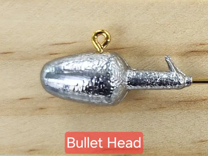 A bullet head is shown on top of wood.