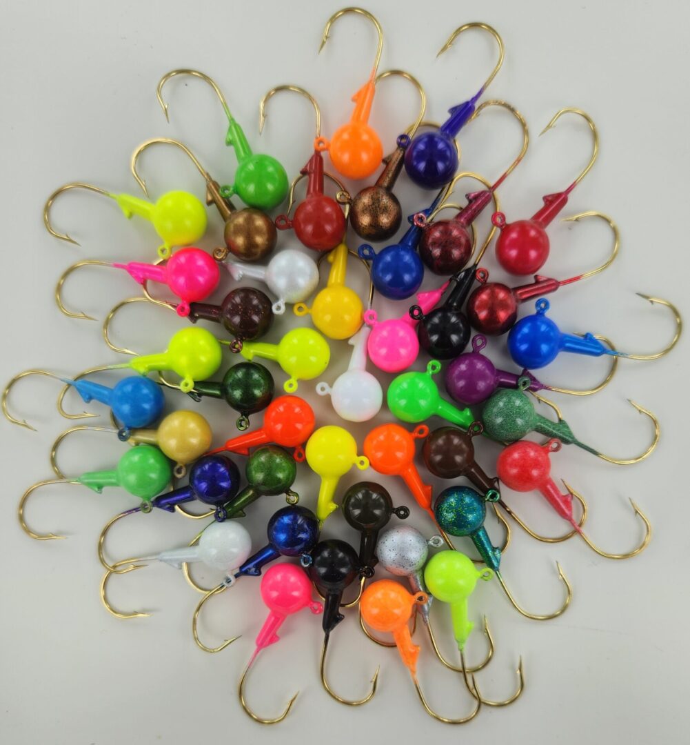 A bunch of different colored fish hooks on a white table