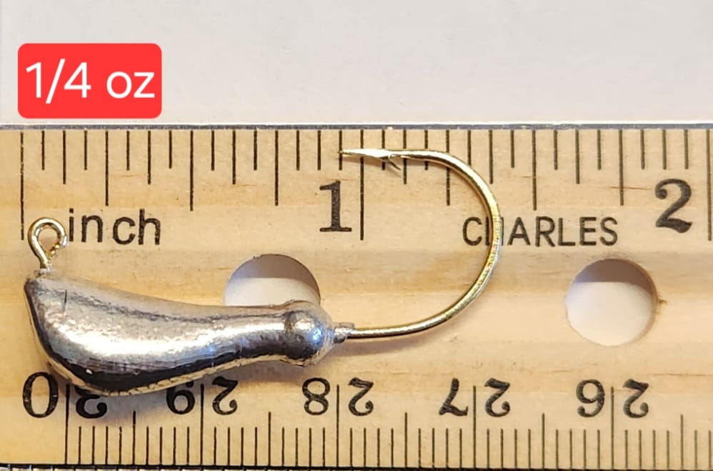 A fishing hook is shown on top of a ruler.