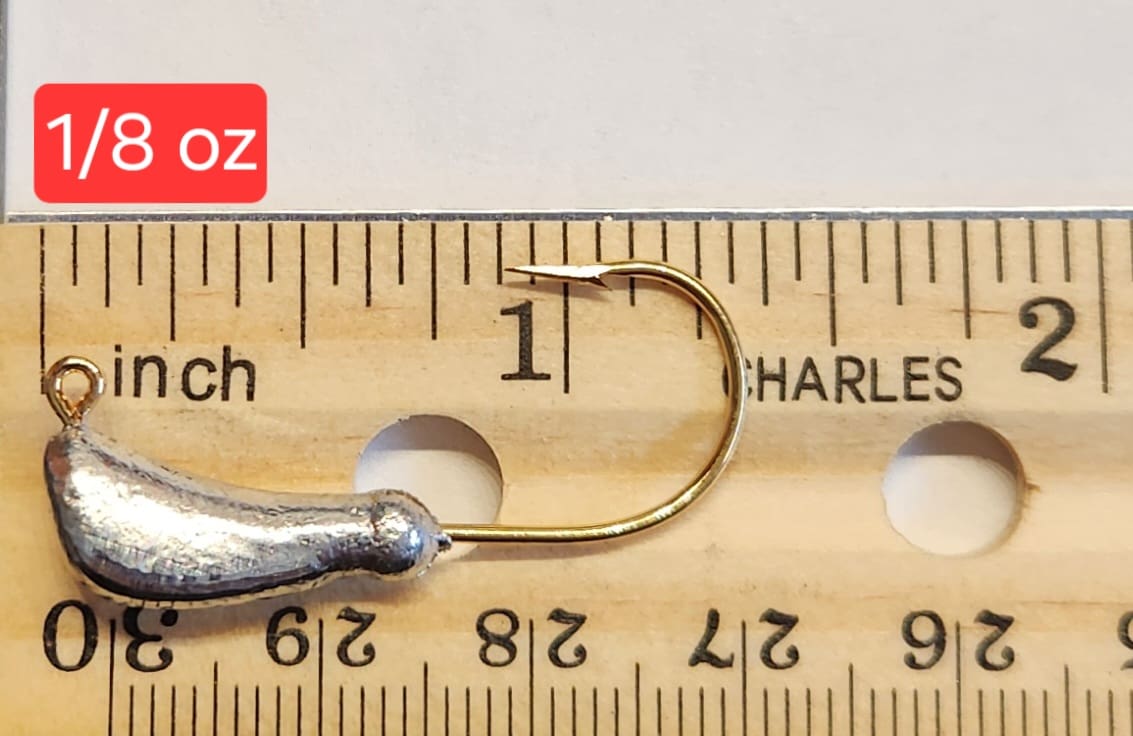 A fishing hook is being measured on the ruler.