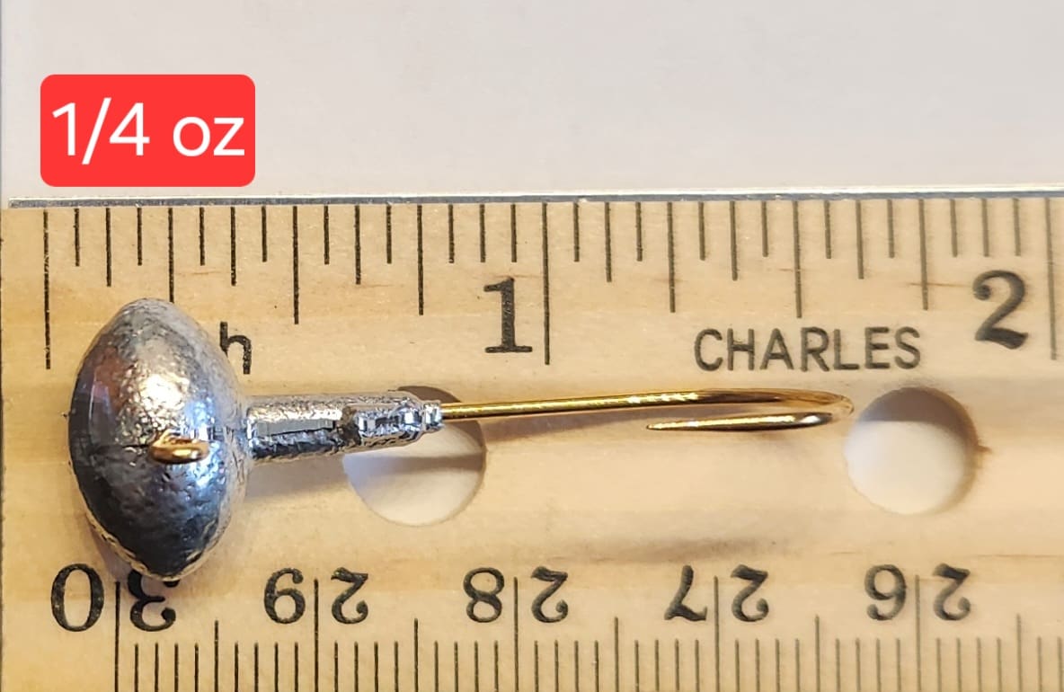 A wooden ruler with a metal needle and a small blue object.