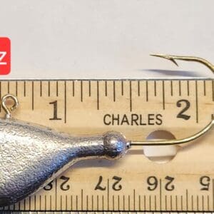 A small metal fish is on the ruler of length.