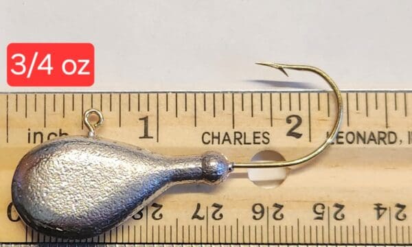 A small metal fish is on the ruler of length.