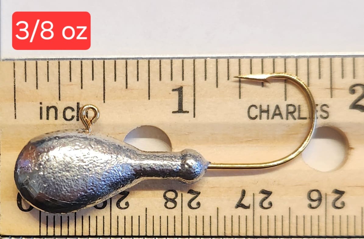 A fishing hook is shown on top of a ruler.