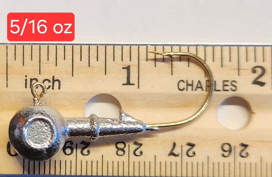 A fishing hook is shown on top of a ruler.