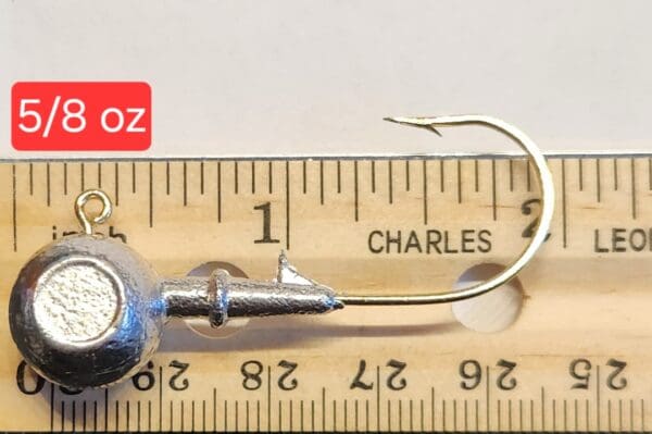 A fishing hook is shown on top of a ruler.