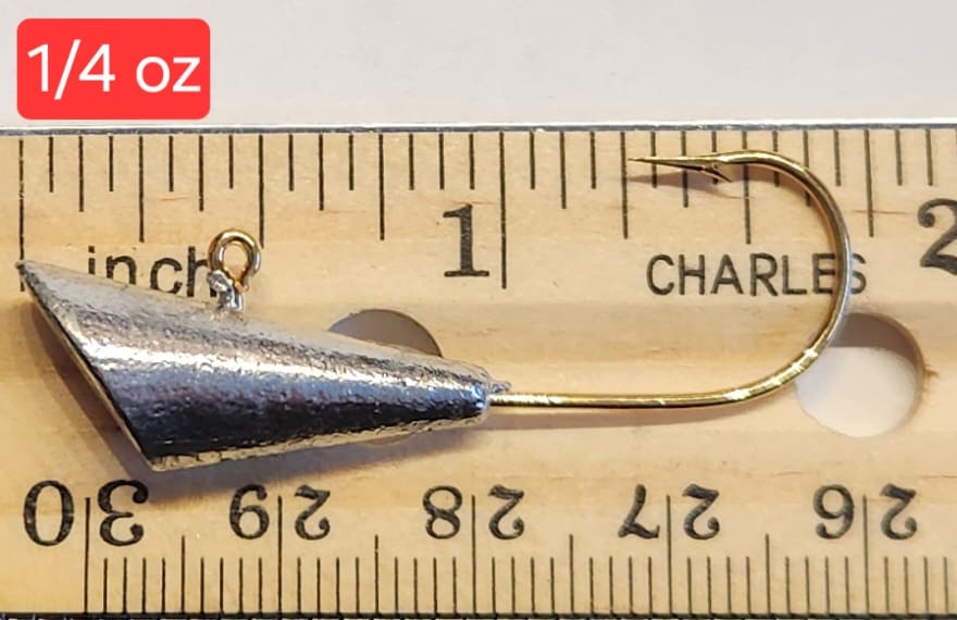 A fishing hook is measured on the ruler.