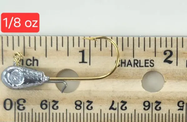 A fishing hook is shown on the side of a ruler.