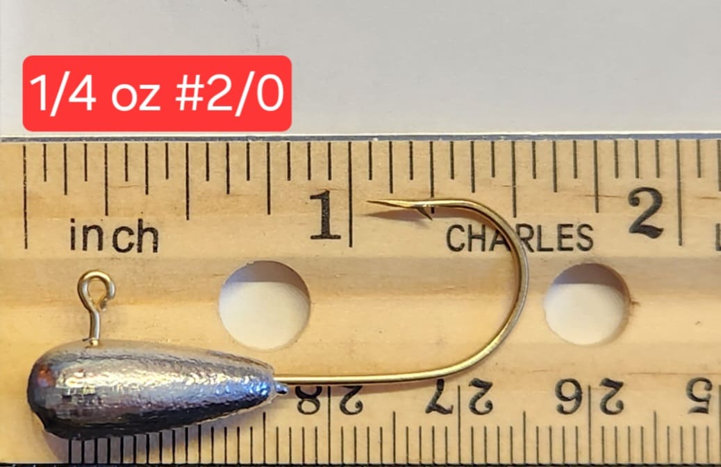 A fishing hook is measured on the ruler.