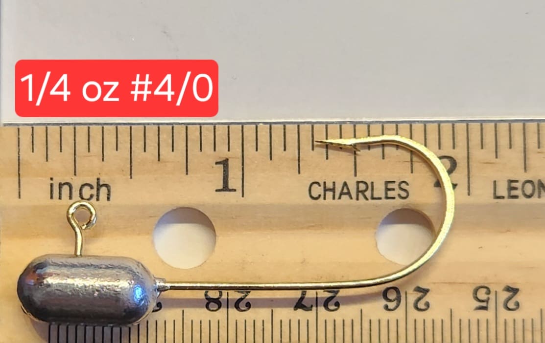 A wooden ruler with a fishing hook and a measuring tape.