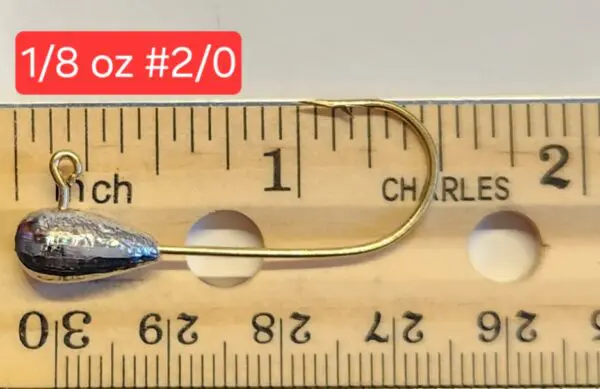 A fishing hook is measured on the ruler.