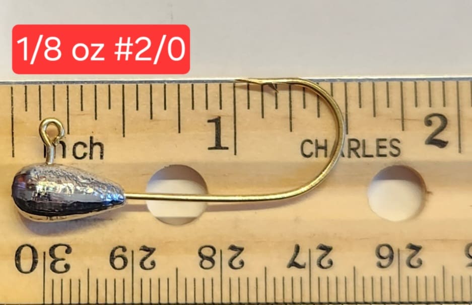 A fishing hook is measured on the ruler.