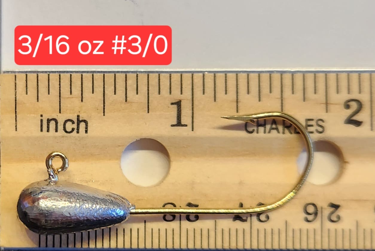 A fishing hook is measured on the ruler.