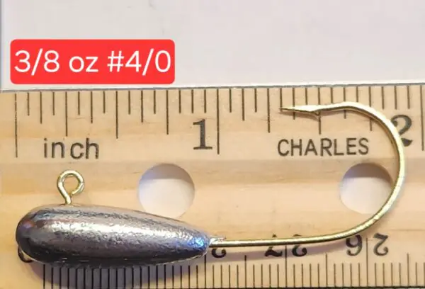 A small metal fish is on top of a ruler.