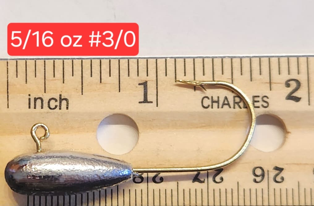 A fishing hook is shown on top of a ruler.