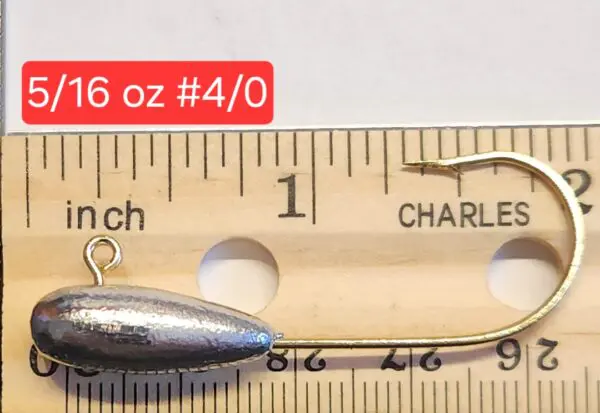 A fishing spoon is on the ruler of length.