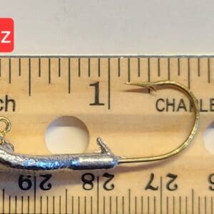 A fishing hook is on the ruler of length.