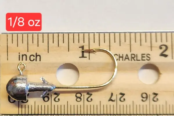 A wooden ruler with a fishing hook and a measuring tape.