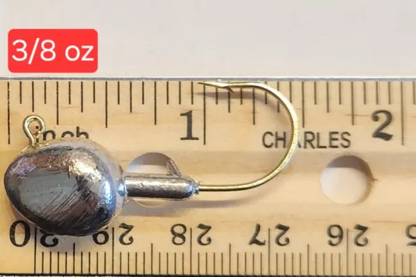 A wooden ruler with a metal hook and a small ball.