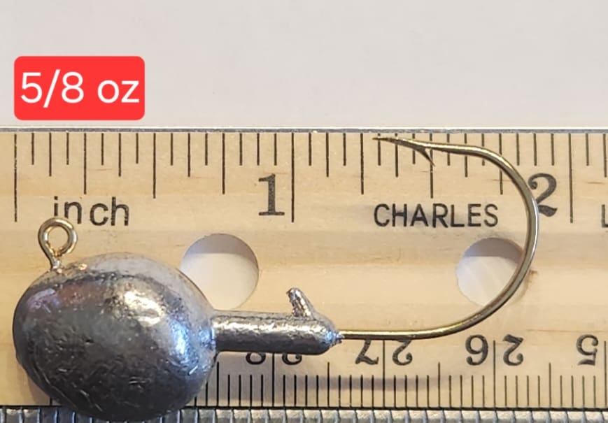 A metal ball and needle on top of a ruler.